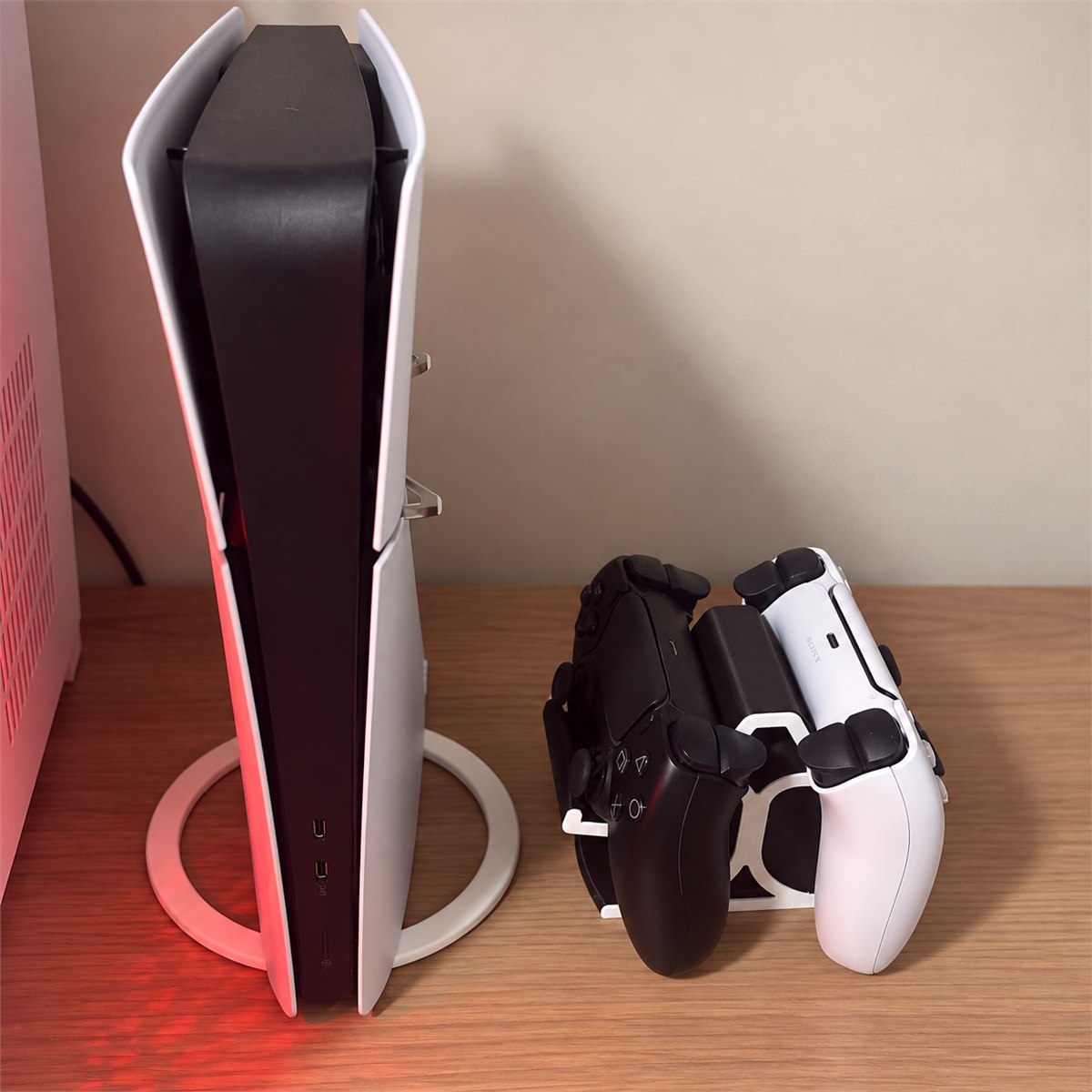 Suporte duplo com dois controles ao lado de um PS5